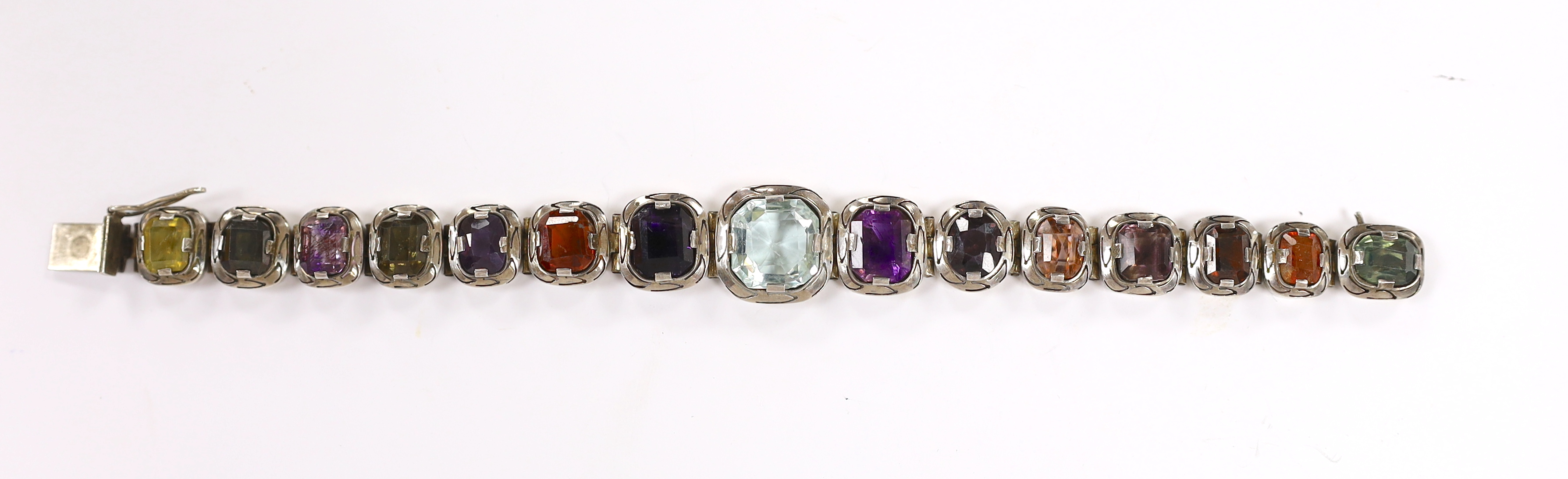 A white metal (tests as silver) and graduated multi gem set bracelet, 17.5cm